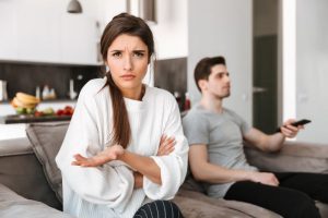 woman on couch annoyed by boyfriend