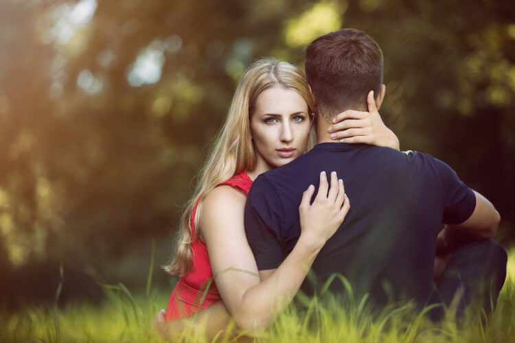 young couple embracing in the park grass