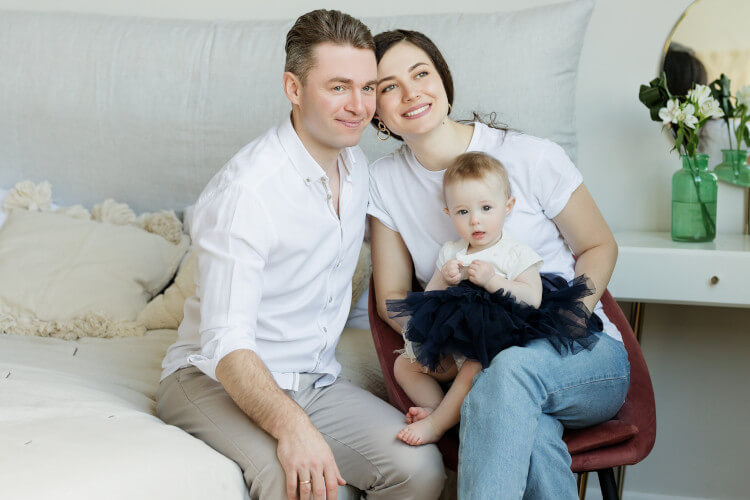 Happy young couple holding an infant