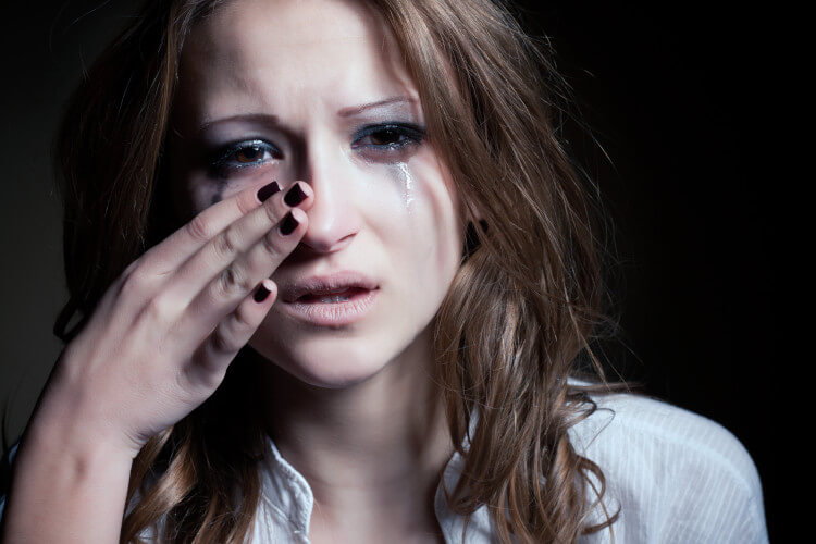 young lady crying and wiping away tears