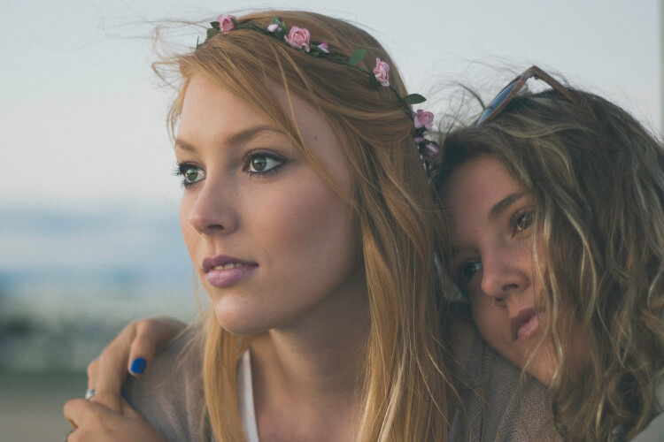 two young female friends sitting outdoors