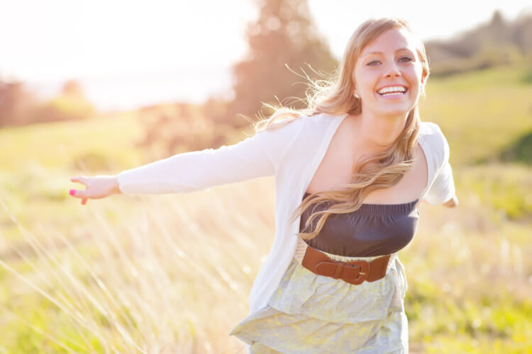 Young lady with a huge smile in a field